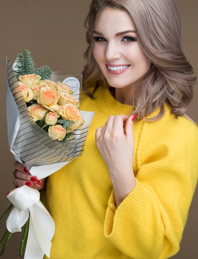 选择聚焦摄影微笑的女人拿着花束
